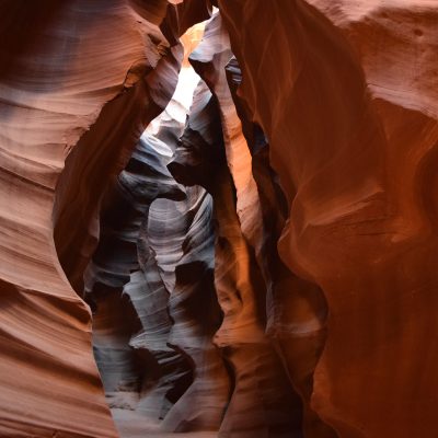 Sunlight illuminating wavy sandstone formations inside a slot canyon.